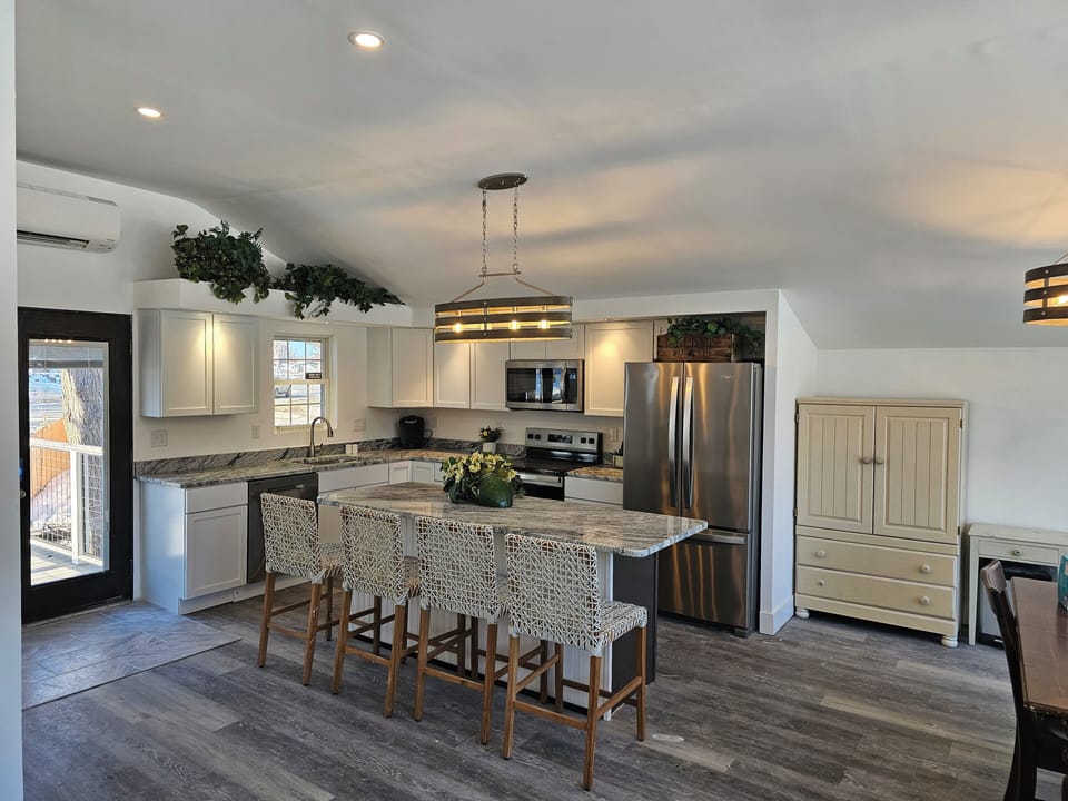 Chef's granite kitchen with island seating and stainless appliances.
