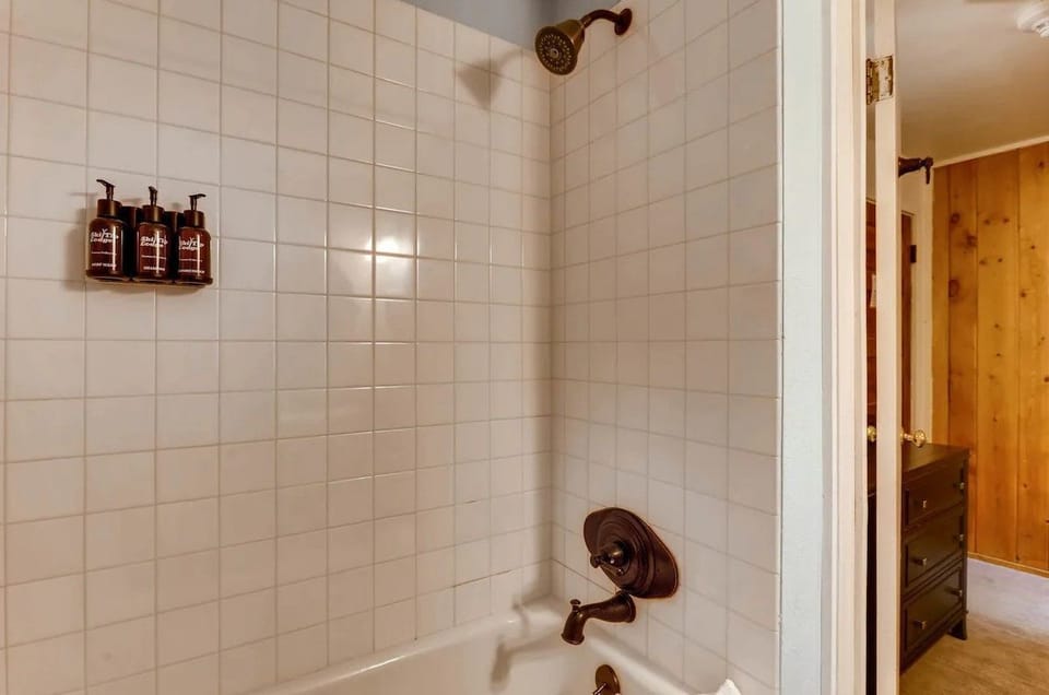 Bright and simple bath area with clean tilework and modern fixtures, perfect for a refreshing start to the day.