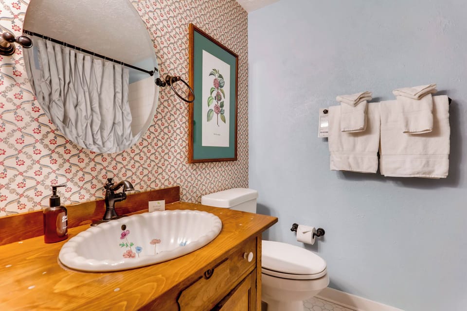 Playful vintage-inspired bathroom with a colorful backsplash and warm wooden vanity, full of character.