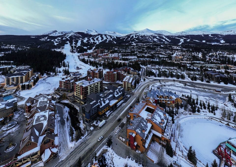 Breathtaking aerial view of a vibrant mountain town, where winter charm meets adventure at every turn.