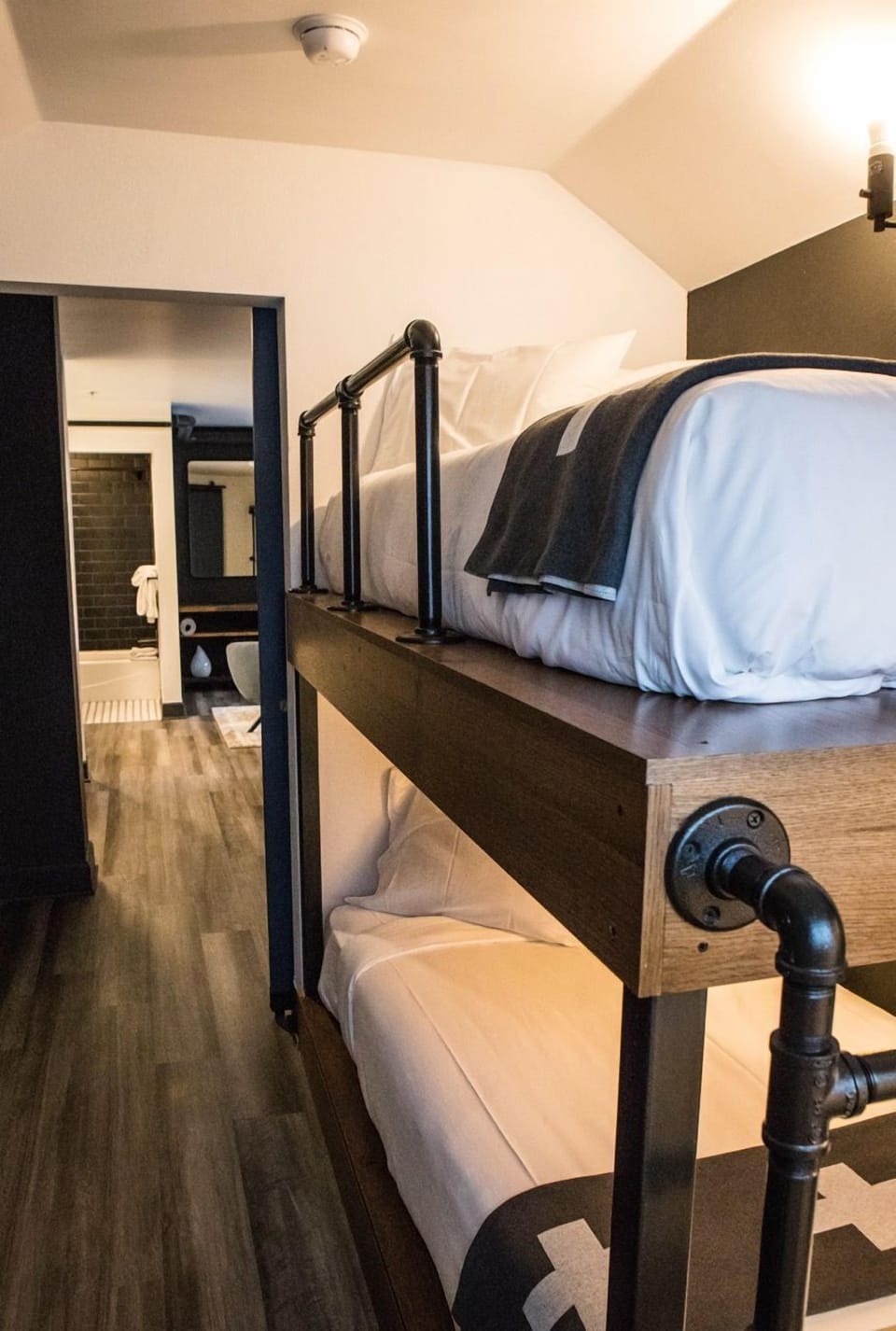 Stylish Pod Room with industrial-style bunk beds, offering a cozy and functional space for a restful stay.