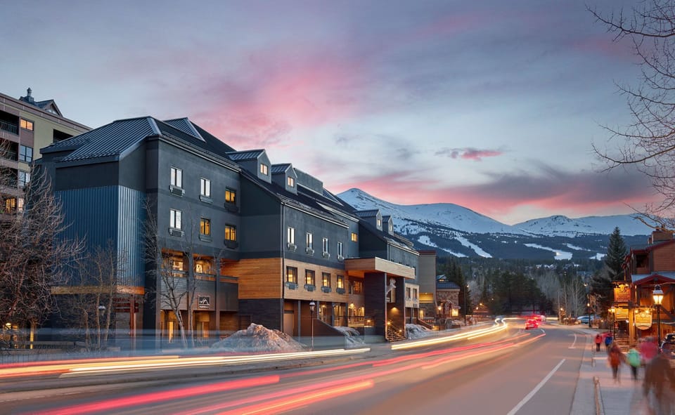 As the sun sets, the town comes to life with warm lights, scenic streets, and a cozy mountain-town atmosphere.