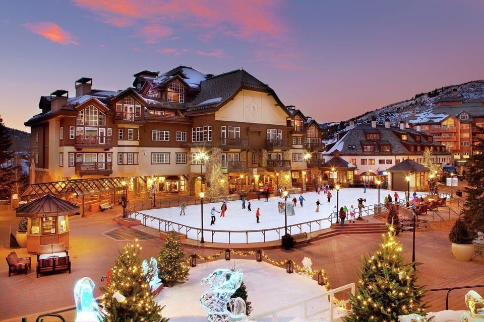 Enchanting village scene with a festive ice skating rink, twinkling lights, and a magical alpine atmosphere.