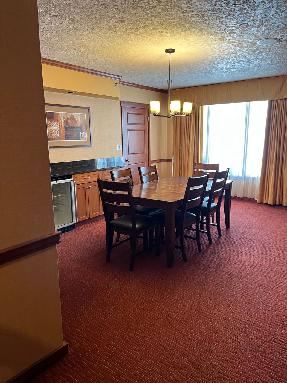Elegant dining area with seating for group gatherings, complemented by large windows and inviting lighting.