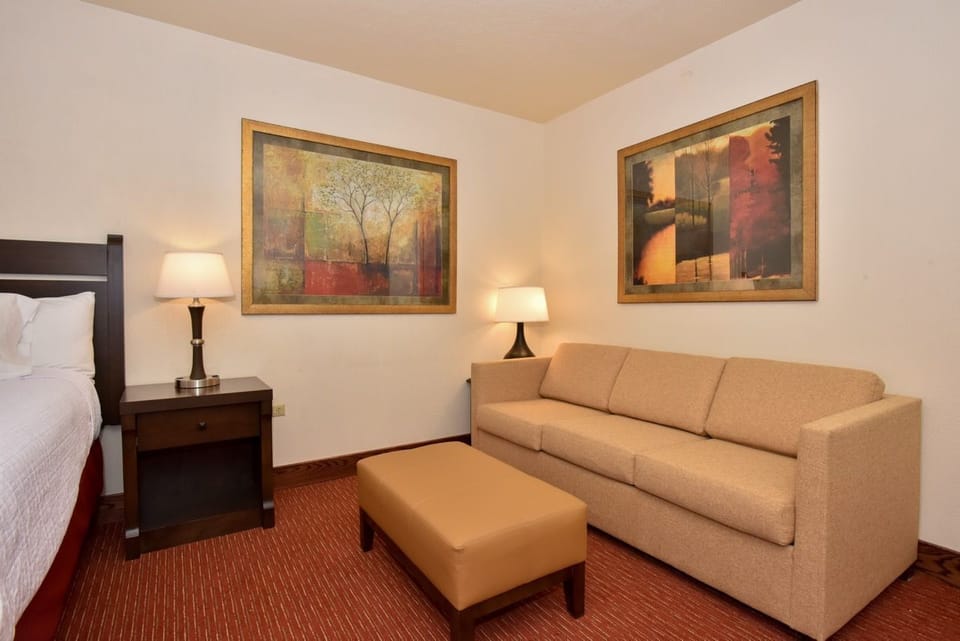 Cozy suite featuring a plush bed, soft lighting, and a relaxing sitting area for ultimate comfort.