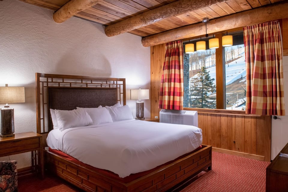 Charming bedroom with rustic wood beams, soft lighting, and cozy decor for a warm and restful ambiance.
