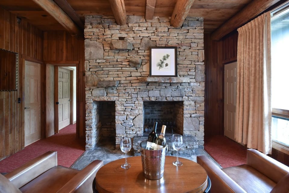 Inviting sitting area featuring a stunning stone fireplace, ideal for relaxing with a glass of wine or cozying up by the fire.