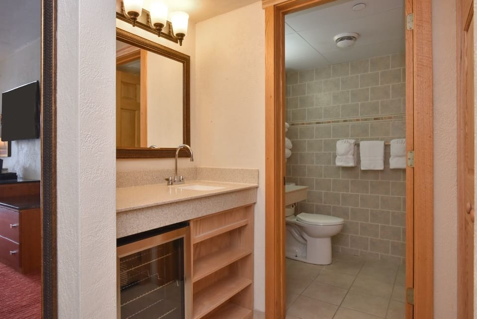 Modern bathroom with a sleek vanity, tiled walls, and thoughtful amenities for a refreshing experience.