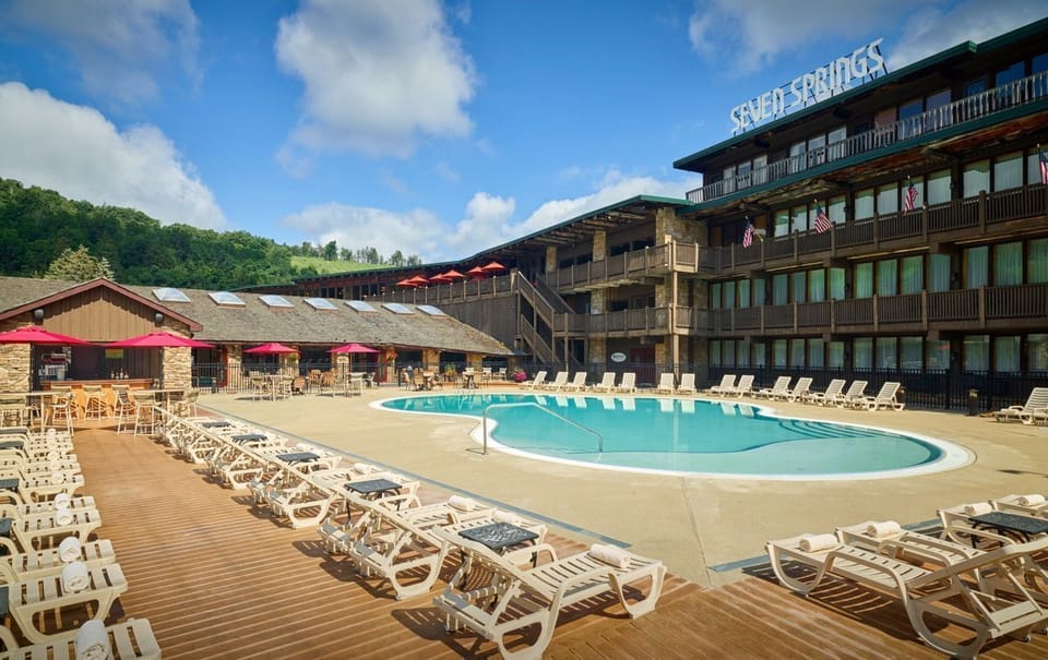 Spacious outdoor pool area surrounded by scenic mountain views and plenty of loungers for soaking up the sun.