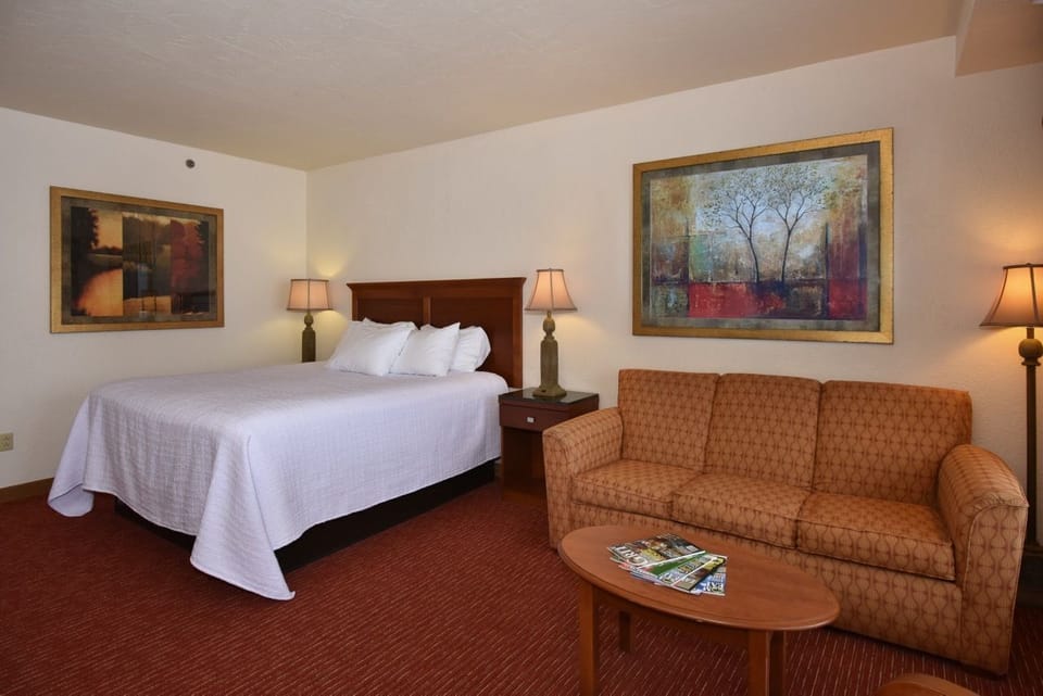 Spacious bedroom with a cozy sitting area, warm lighting, and inviting decor for ultimate relaxation.