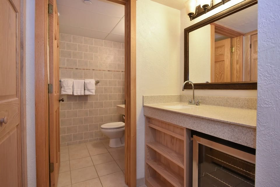 Modern bathroom featuring a sleek vanity, natural wood accents, and a refreshing walk-in shower.