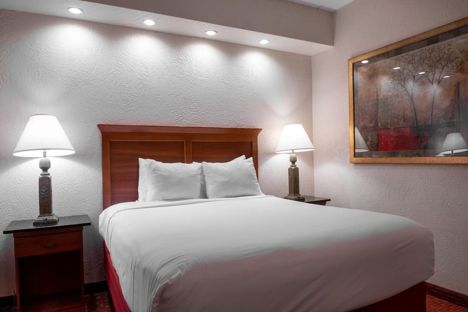 Cozy bedroom with soft lighting, elegant decor, and a plush bed for a restful night's sleep.