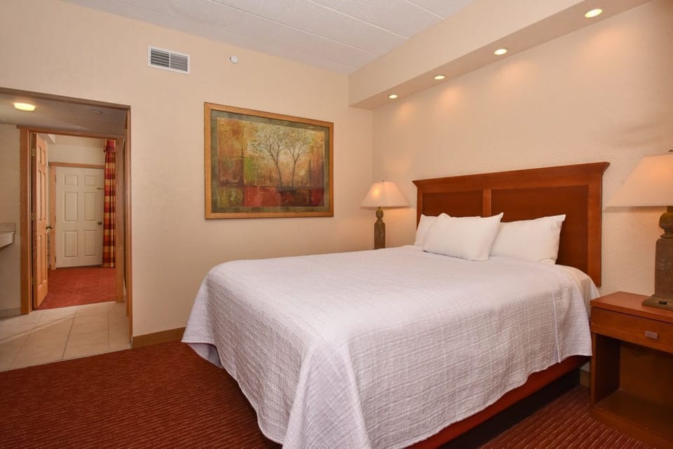 Elegant bedroom featuring modern accents, a plush bed, and warm lighting for a tranquil and inviting atmosphere.