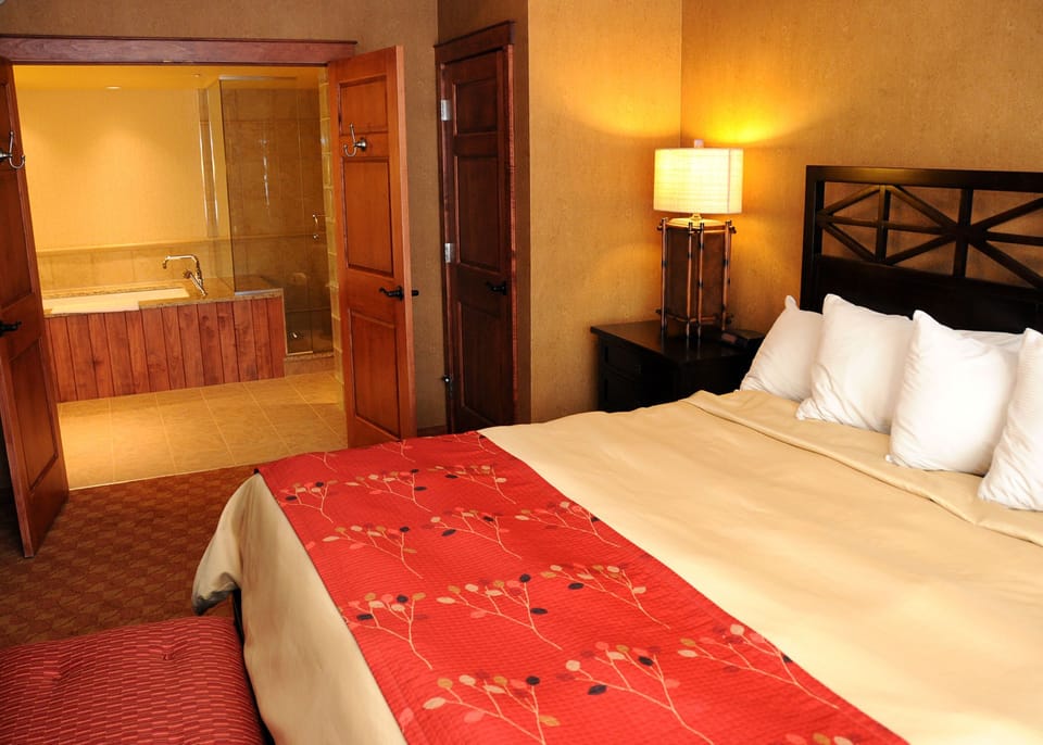 Elegant bedroom with a plush bed, warm tones, and an ensuite bath for added comfort and convenience.