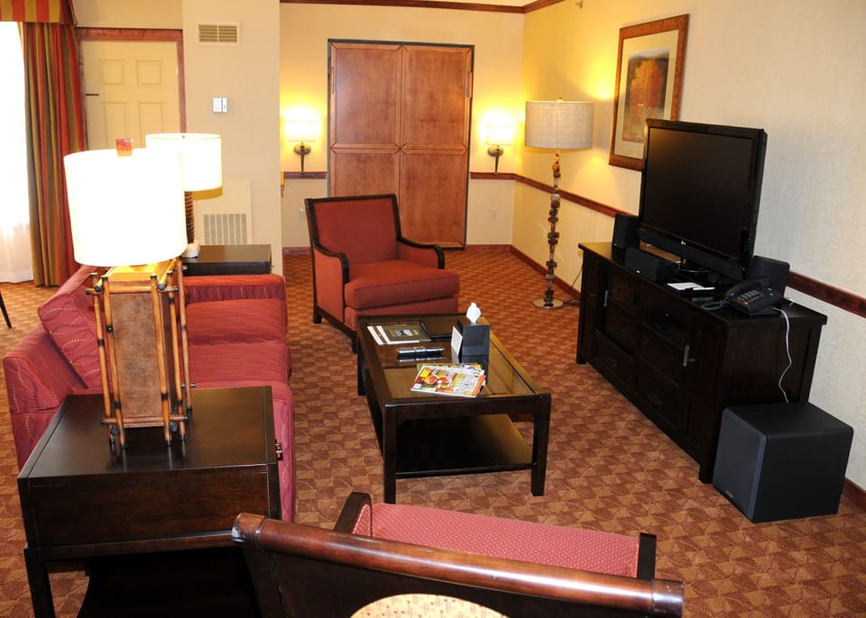 Cozy living room featuring inviting seating, warm lighting, and a flat-screen TV for ultimate relaxation.
