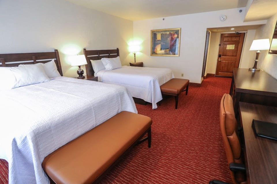Spacious room with plush beds, cozy seating, and warm lighting, creating a comfortable and inviting atmosphere.