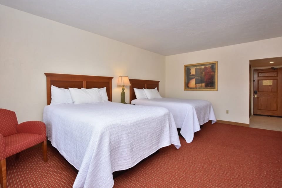 Spacious bedroom featuring three plush beds, warm tones, and plenty of room for a restful and relaxing stay.