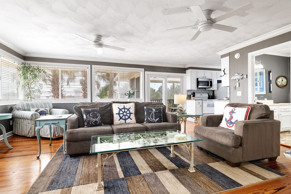 Sliding doors and large windows flood the living and dining space with natural light, creating a bright and welcoming atmosphere throughout.