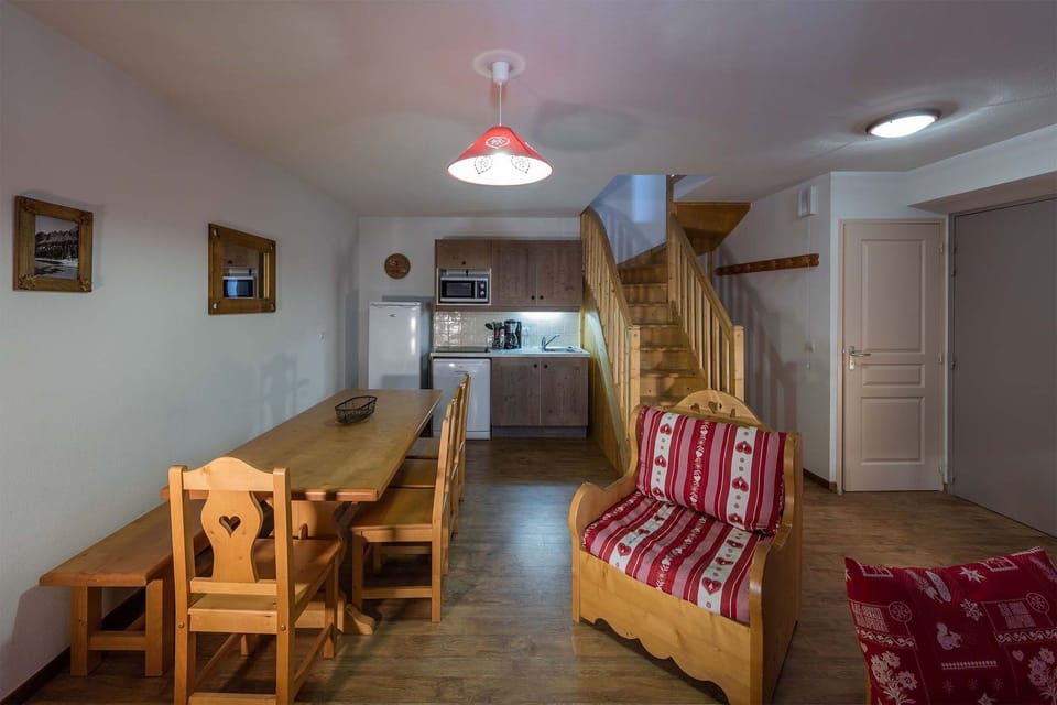 Traditional wooden furnishings and a bright open-plan living space create an inviting mountain retreat.