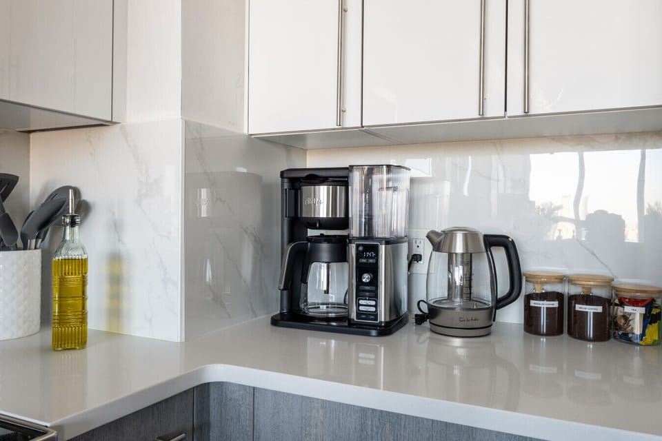 Coffee maker, hot water kettle, coffee grounds, tea, olive oil and cooking utensils
