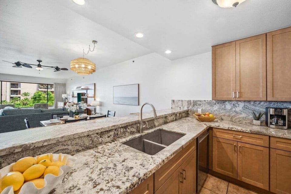Matching granite backsplash and tiled floors, layout flowing seamlessly into the living area.