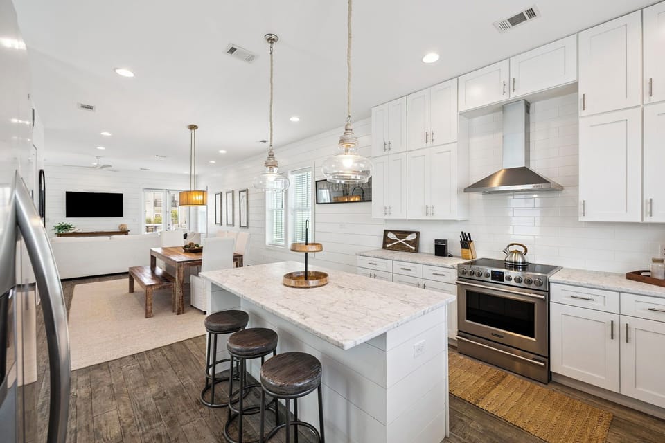 Your dream kitchen awaits with gleaming white cabinets, marble island seating, and chef-grade appliances for memorable meals together.