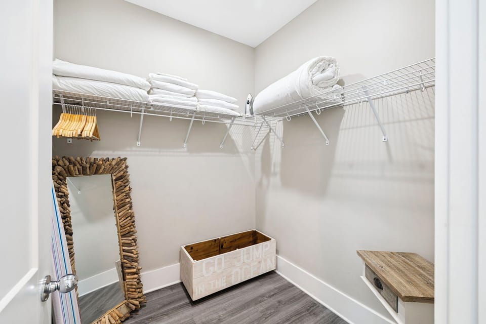 Your walk-in closet features ample hanging space, organized shelving, and a convenient bench for getting ready.