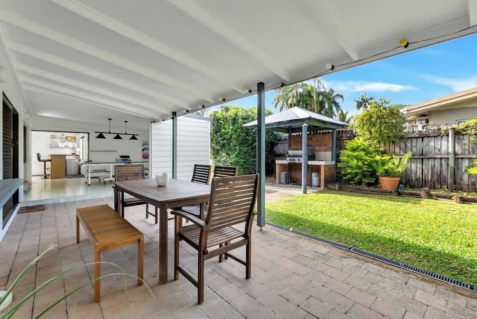Dine outdoors on the sheltered patio, featuring an alfresco dining area and a BBQ grill—perfect for relaxed meals surrounded by lush greenery.