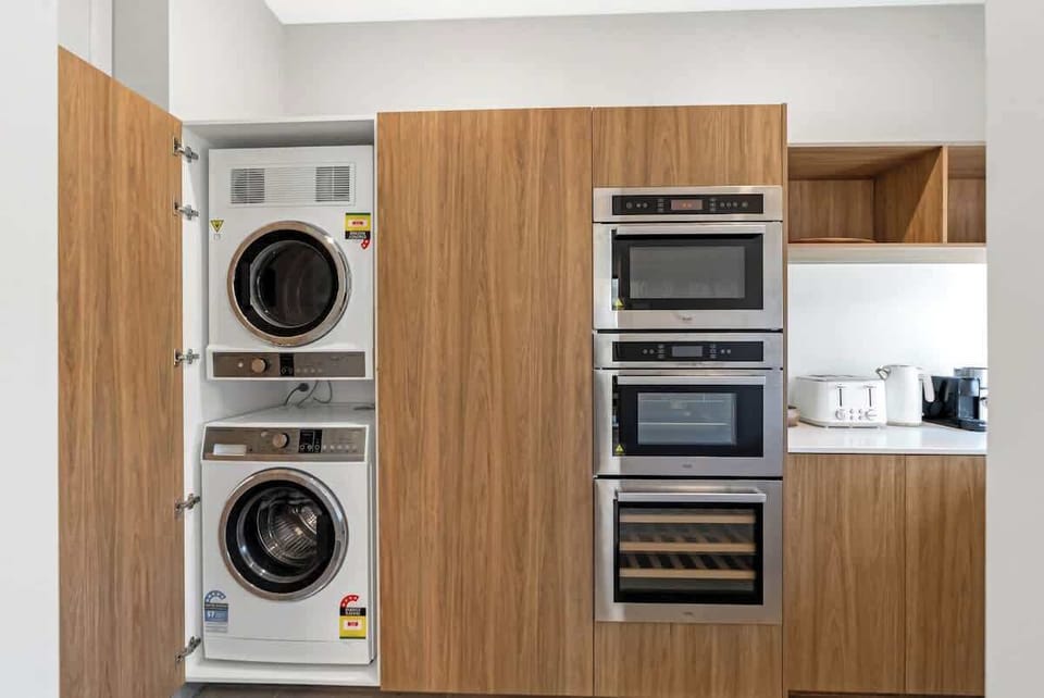 Keep things effortless with a discreetly built-in washer and dryer, neatly tucked within the kitchen cabinetry.