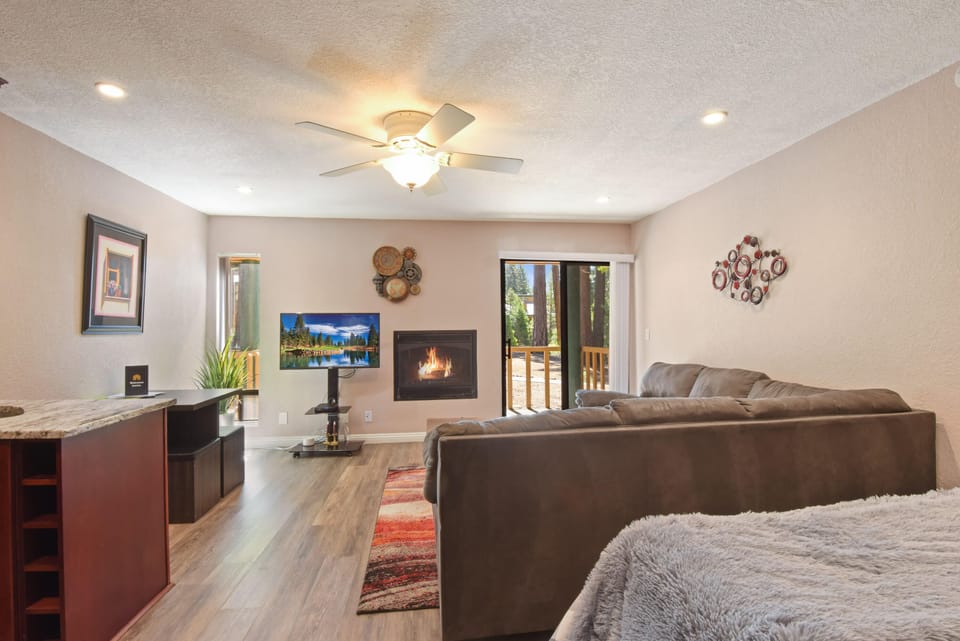 Studio living room with Smart TV, gas fireplace, dining area and murphy bed