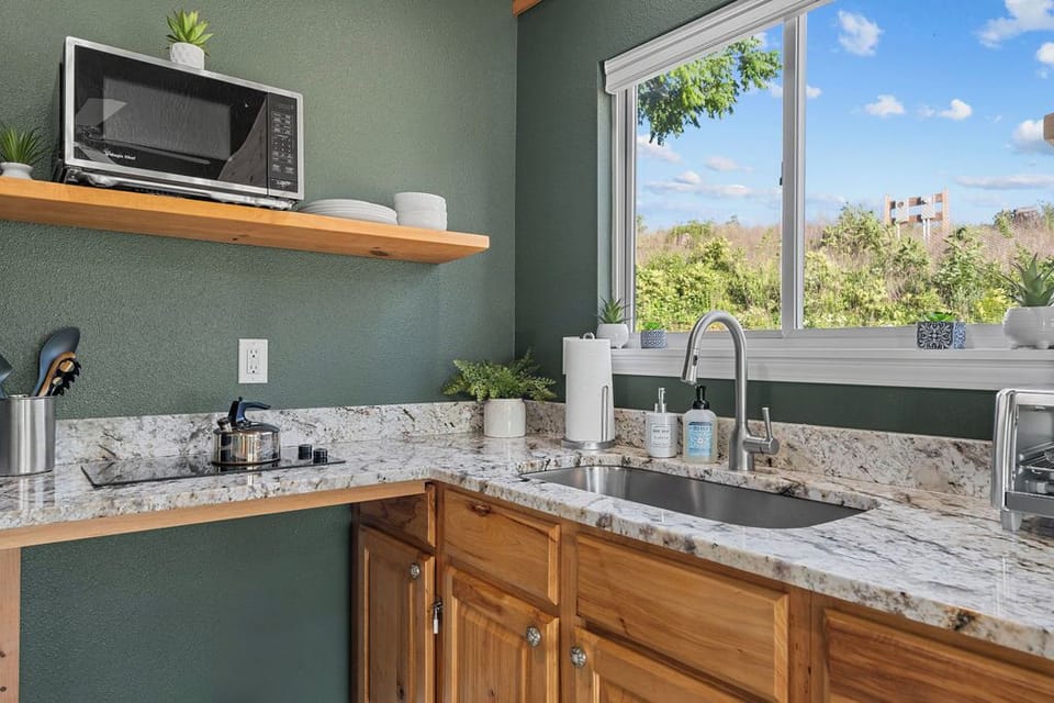 Prepare meals with ease in a bright, modern kitchen overlooking nature.