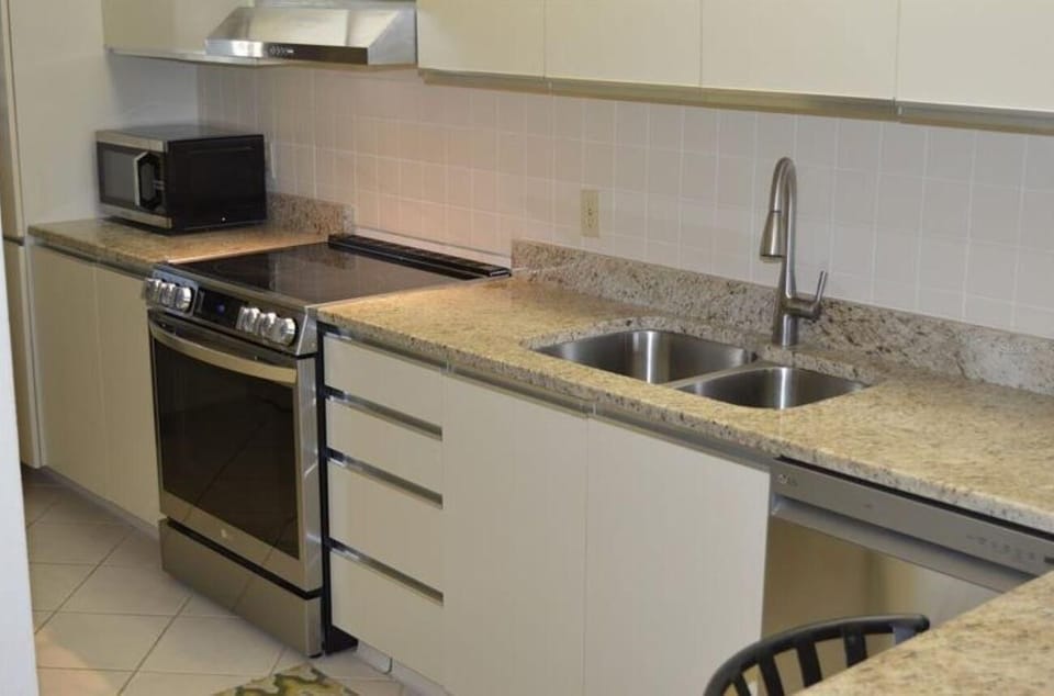 Kitchen features granite countertops, dual stainless steel sinks, white tile backsplash, and modern appliances.