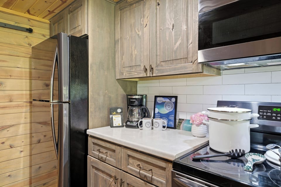 Enjoy a fully stocked kitchen setup with modern appliances, plenty of counter space, and cozy wood finishes that make every meal feel right at home.