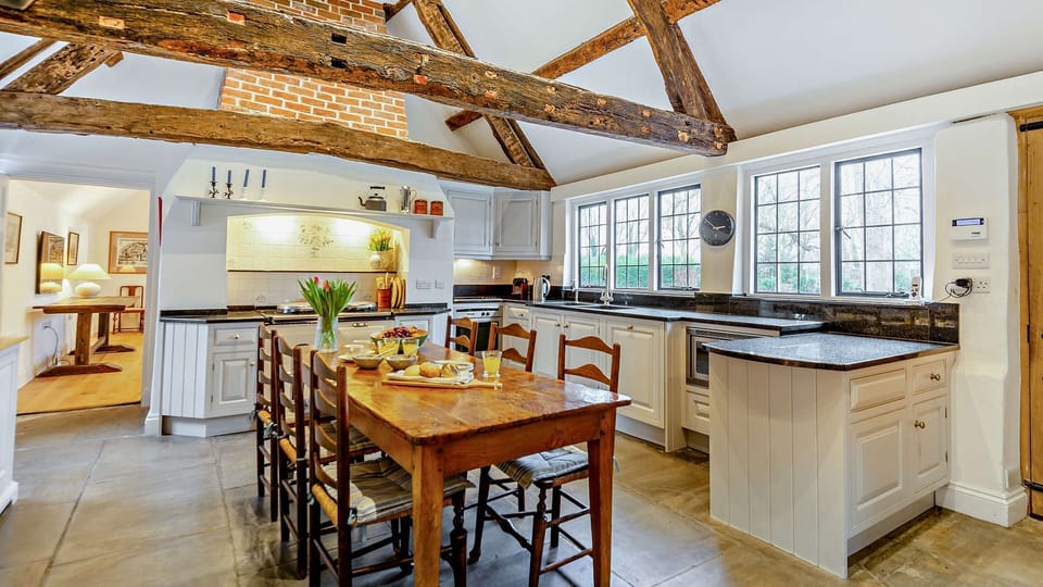 High ceilings with wooden beams and flagstone flooring frame this historic kitchen