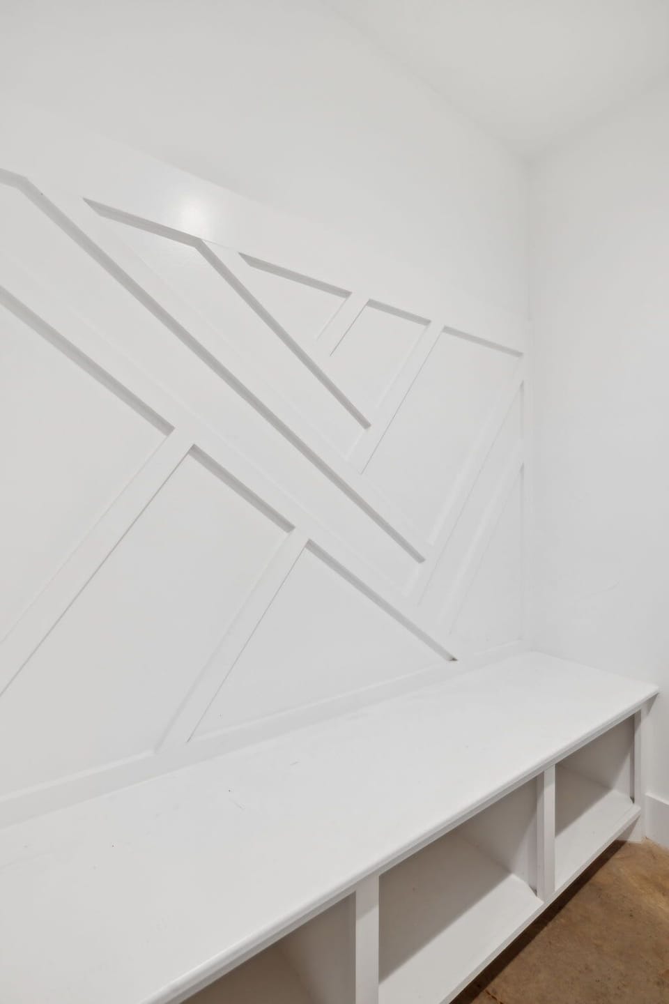  A custom-designed mudroom with built-in storage and a modern geometric accent wall.