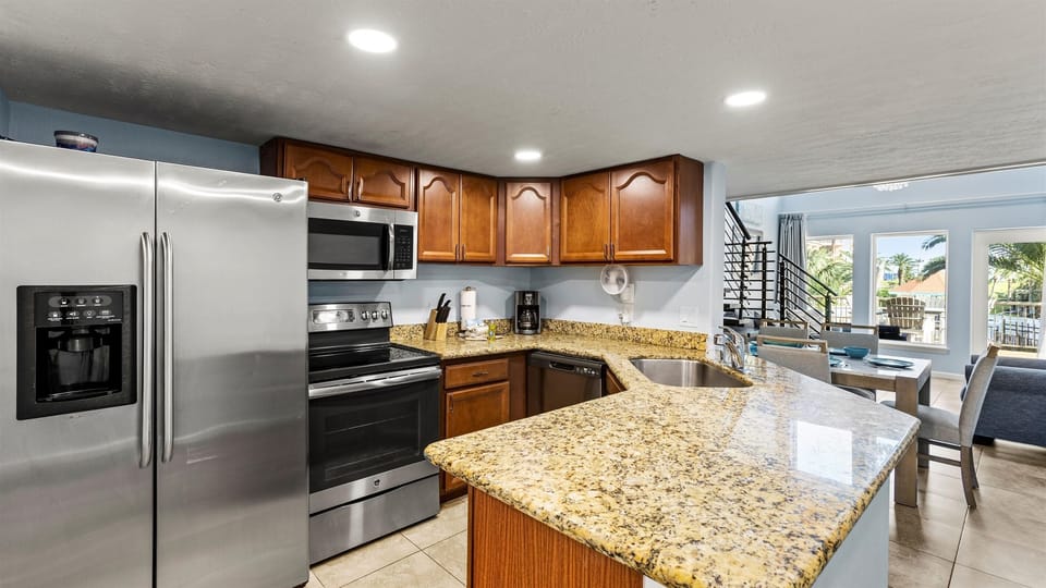 Kitchen features granite counters and full size stainless appliances.