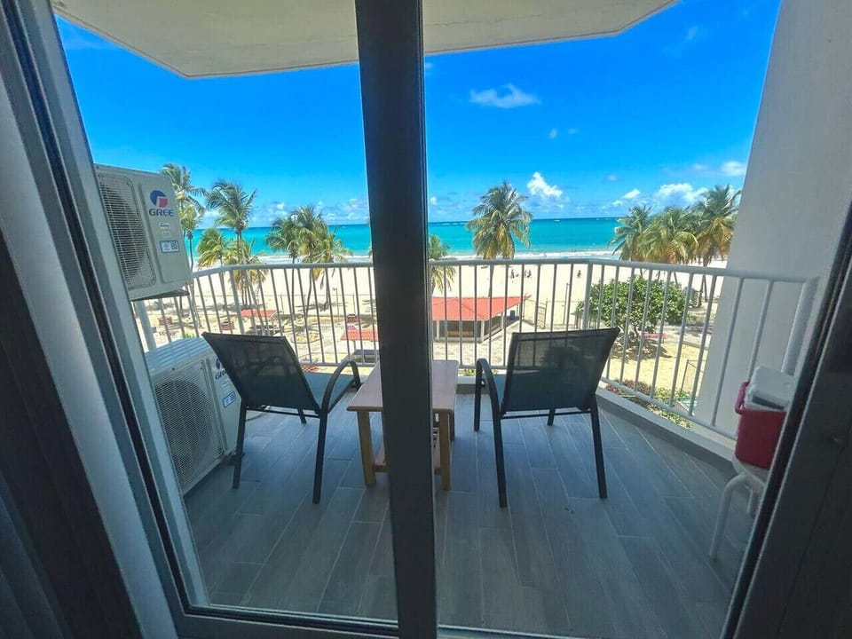 Peaceful balcony views of the beach, dotted with gentle rows of umbrellas