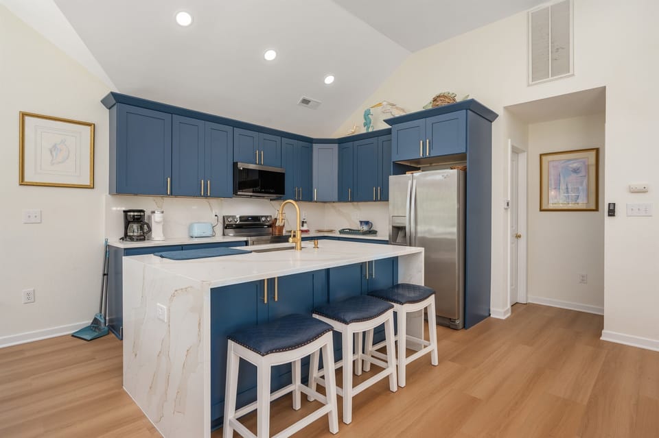 Modern, open-concept kitchen with vibrant blue cabinets and a spacious island for cooking or casual dining.