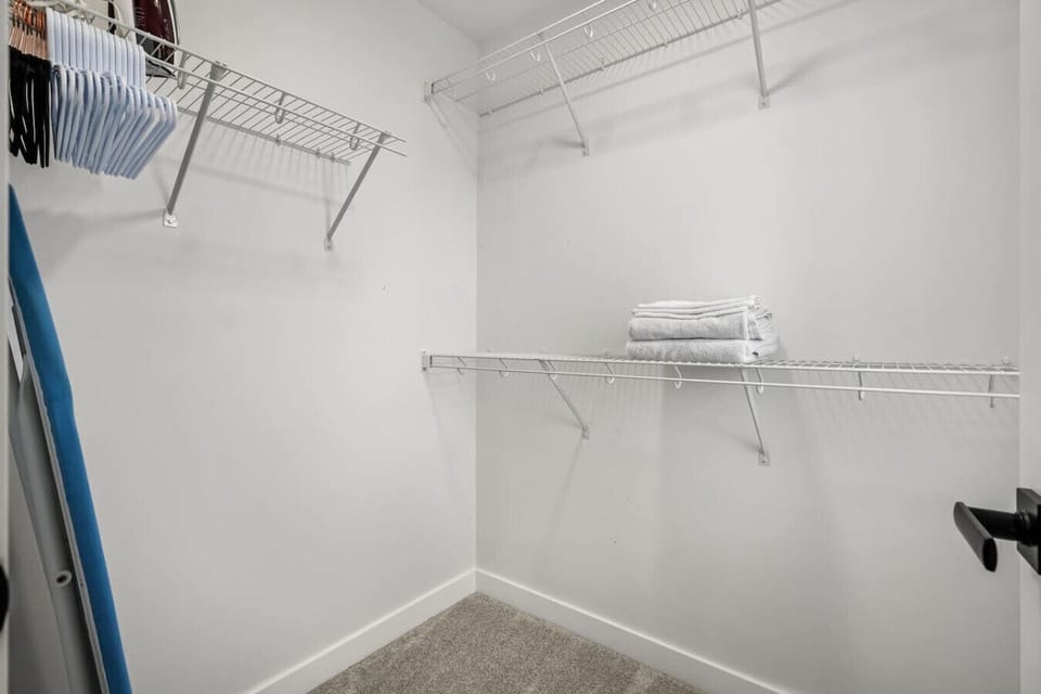 Primary bedroom, located upstairs, with a king bed, 55` Roku TV, closet, dresser, blackout curtains and a private ensuite full bathroom.
