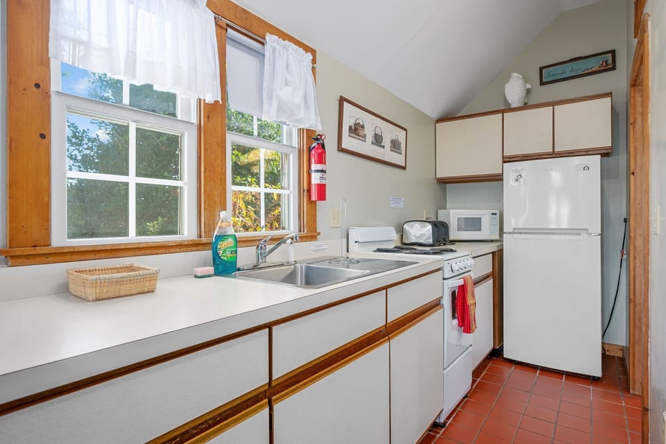Galley kitchen with full fridge, stove/oven and microwave