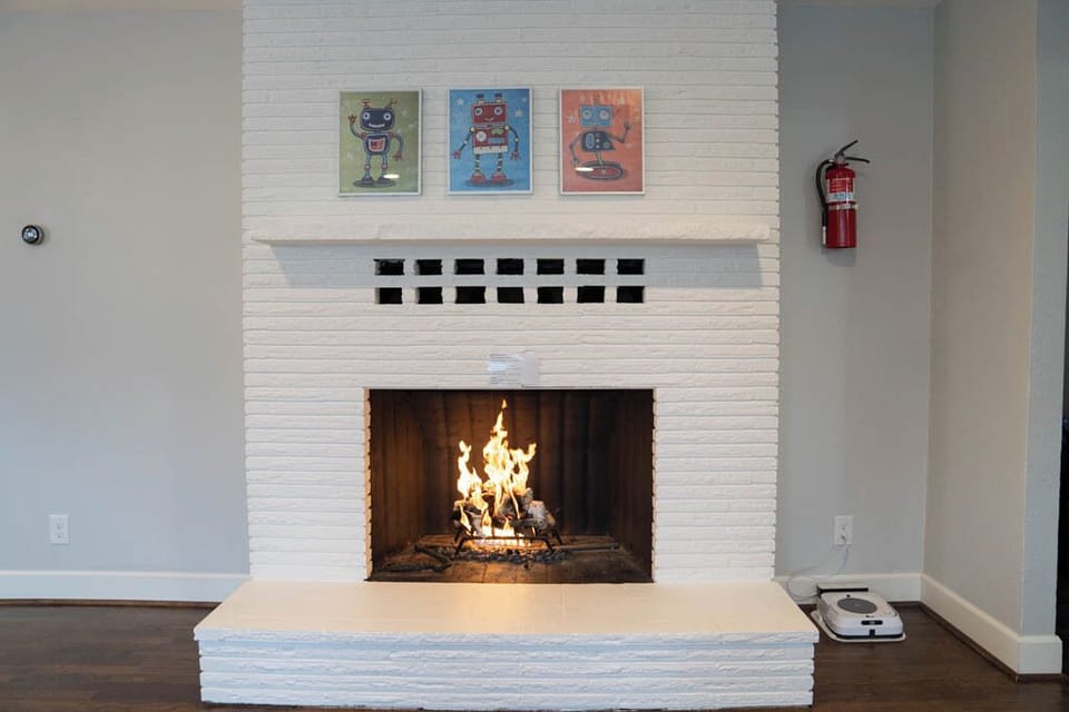 Manual gas fireplace with ceramic log insert.