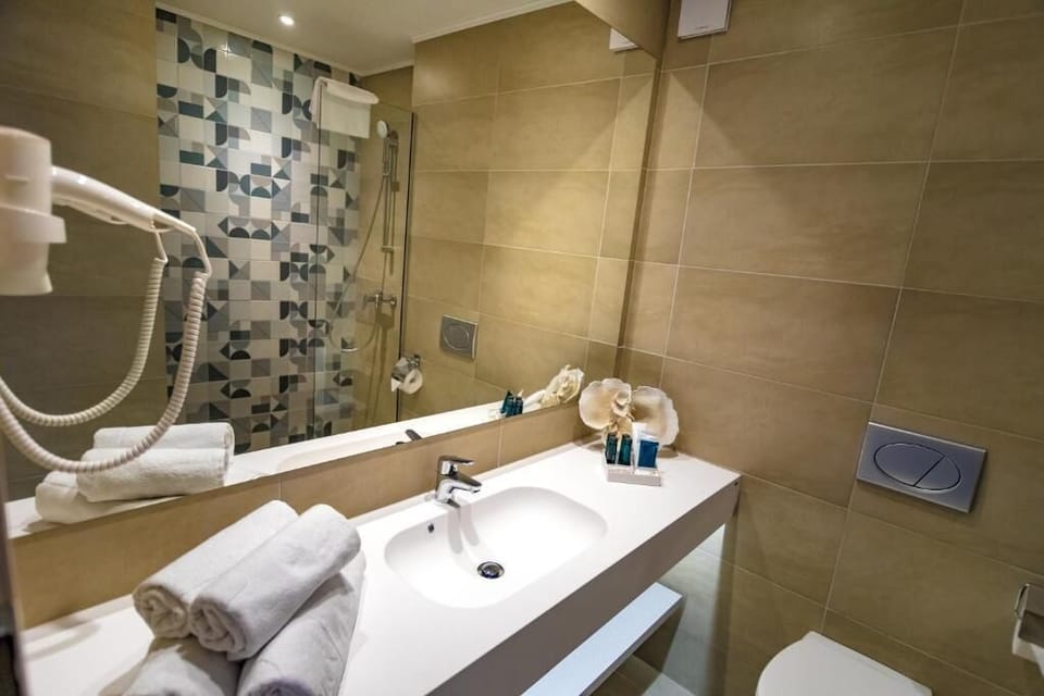 Deluxe Triple Room, Balcony | Bathroom | Shower, hair dryer, slippers, towels