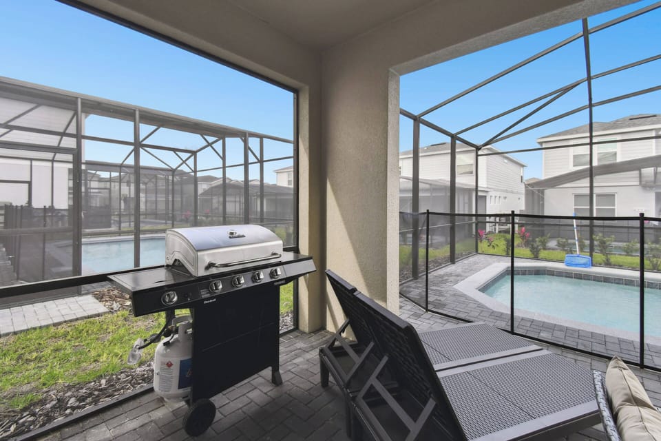 Step outside to your private oasis featuring a sleek grill by the shimmering pool. Relax on comfortable lounge chairs in a serene atmosphere created by the screened enclosure, perfect for enjoying sunny days.