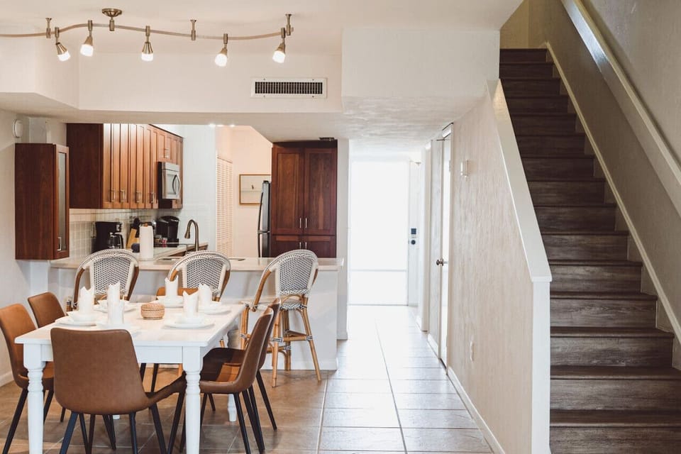 Open dining area with seating for 6, flowing into the fully equipped kitchen — perfect for family meals between beach days at Butler Beach