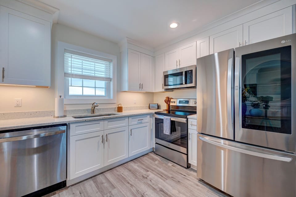 Your fully equipped kitchen features stainless steel appliances, granite countertops, and crisp white cabinetry for effortless meal preparation.