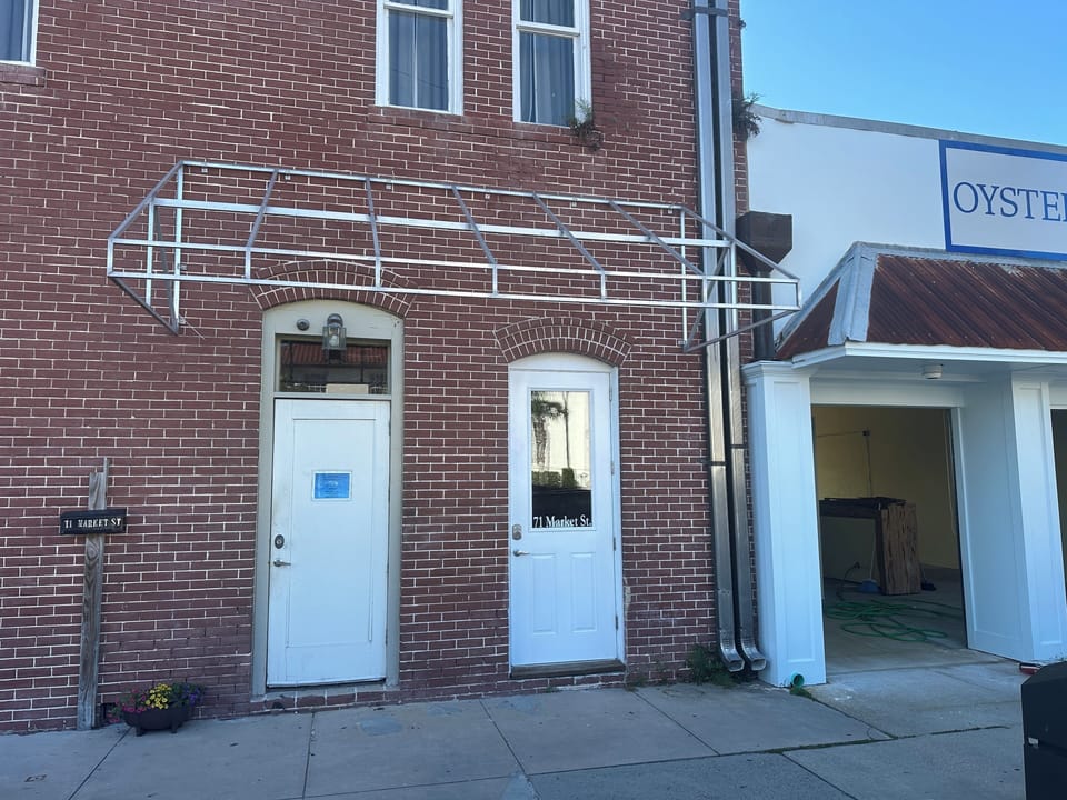 Main entrance is the door on the right across from the post office