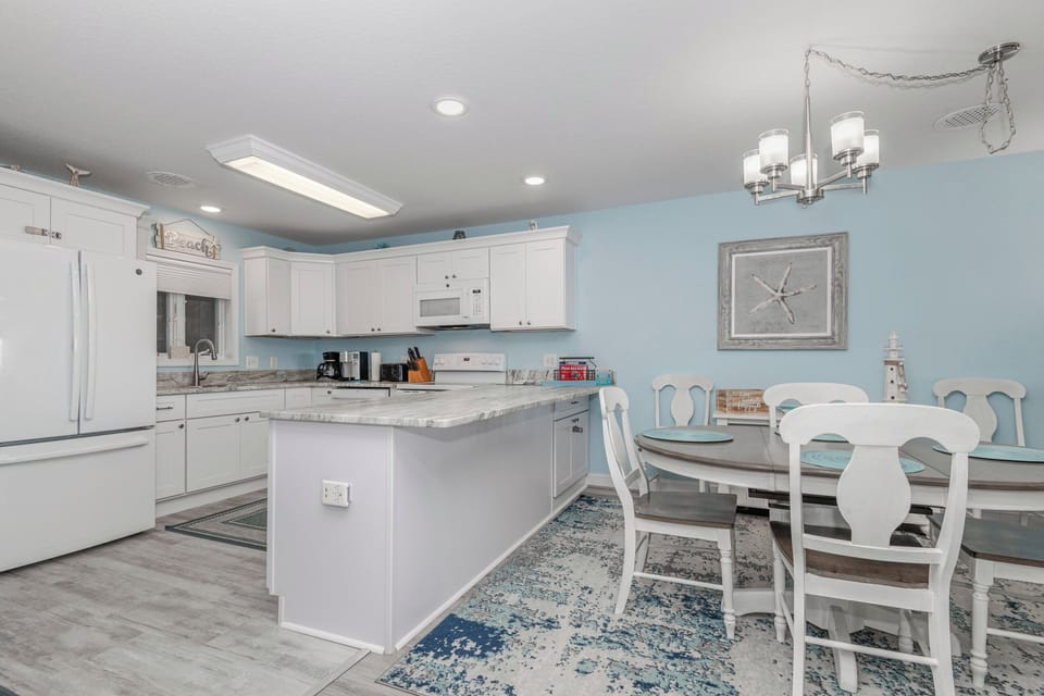 An open dining and kitchen area with a fresh coastal theme
