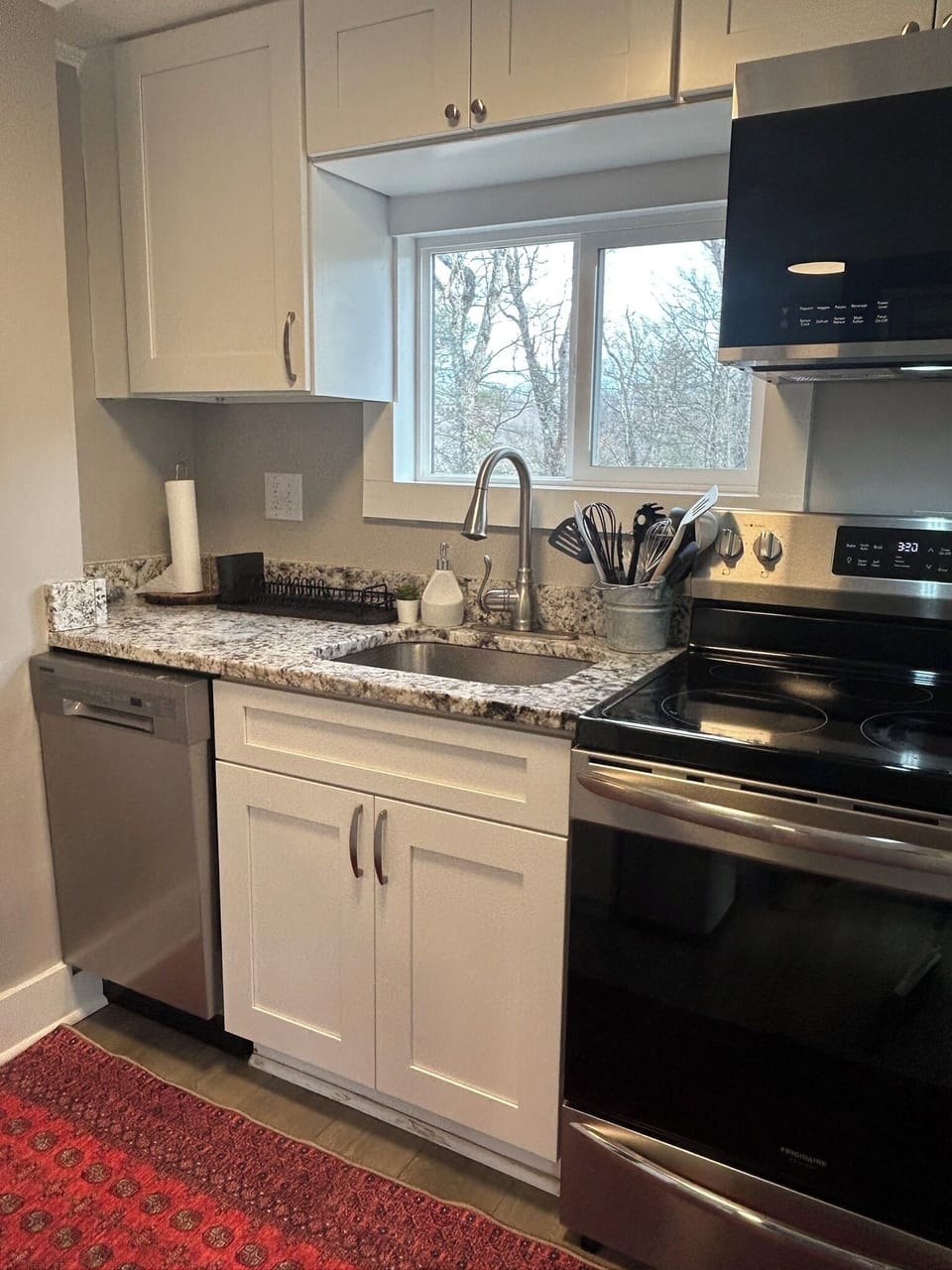 Full-size stove and oven, microwave, and compact dishwasher.