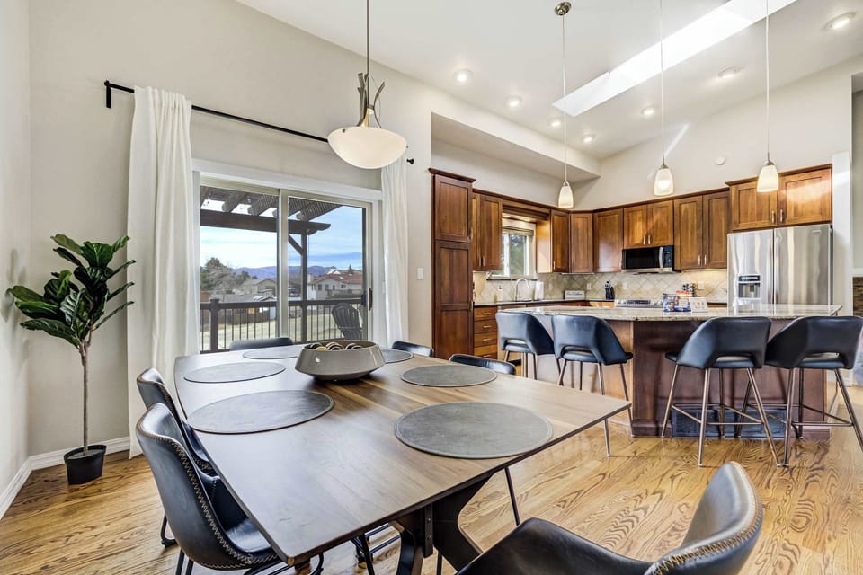 The dining area flows effortlessly into the gourmet kitchen, creating a central hub for conversation and meals. Warm wood cabinetry and sleek granite countertops define this modern space, which is bathed in natural light.
