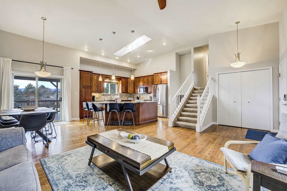 This wide view showcases the incredible flow of the main level, from the cozy lounge to the expansive kitchen. With high vaulted ceilings and a skylight, the home feels bright and airy, perfect for group entertaining.